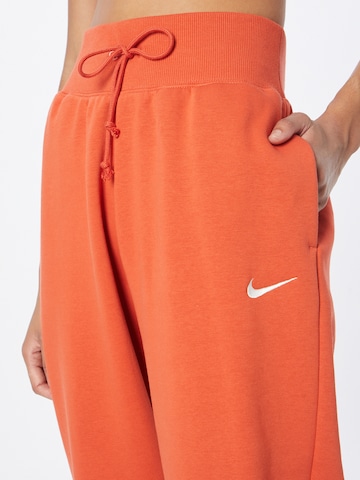 Nike Sportswear - Tapered Calças 'Phoenix Fleece' em laranja
