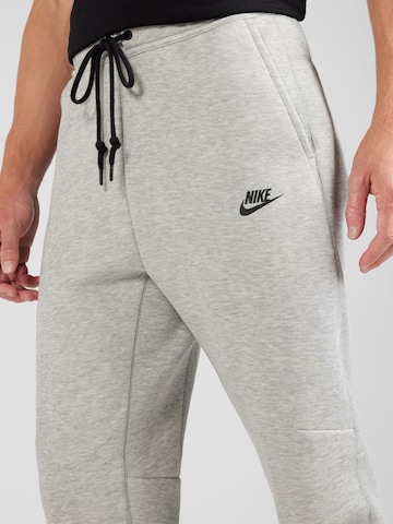 Nike Sportswear Tapered Housut 'TECH FLEECE' värissä harmaa