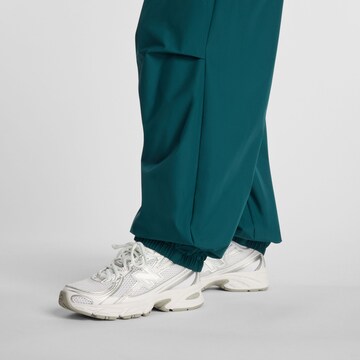 new balance Loosefit 'Trackside Woven Pant'. in Grün