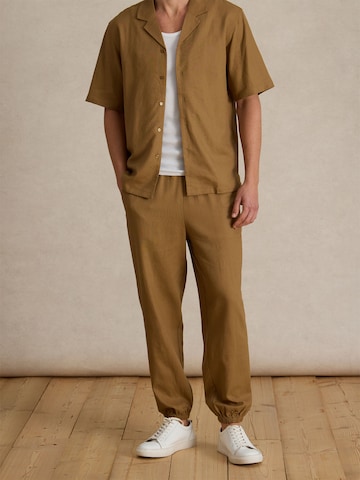 DAN FOX APPAREL Дънки Tapered Leg Панталон 'Gino' в кафяво: отпред