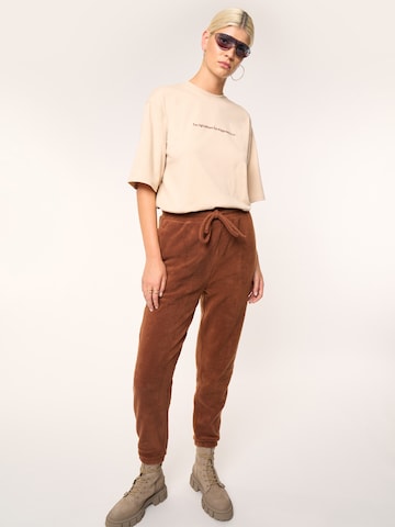 ABOUT YOU x Laura Giurcanu Tapered Pants 'Holly' in Brown