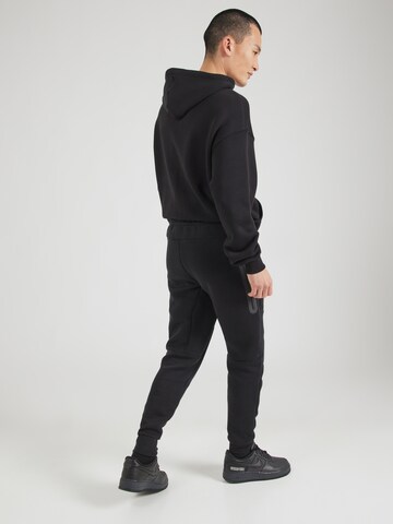 Nike Sportswear Tapered Παντελόνι 'TCH FLC' σε μαύρο