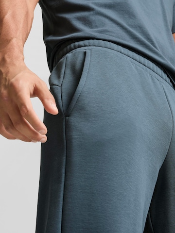PUMA - Tapered Calças de desporto 'ESS+' em azul