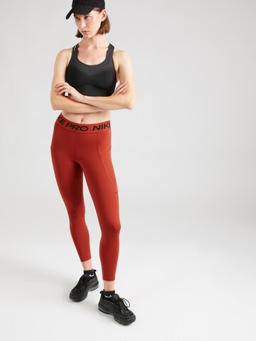 NIKE Skinny Workout Pants in Orange