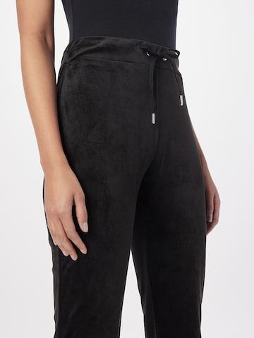 Gina Tricot Flared Bukser 'Melinda velour trousers' i sort