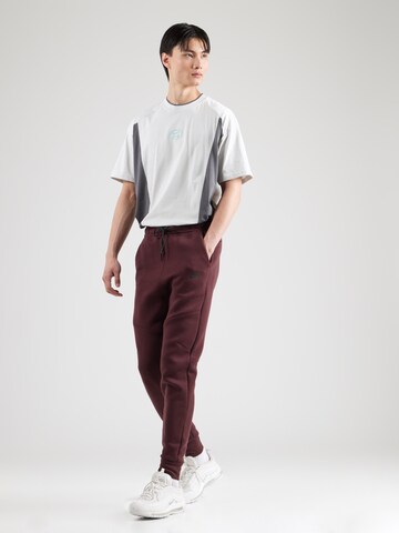 Tapered Pantaloni 'TCH FLC' de la Nike Sportswear pe roșu