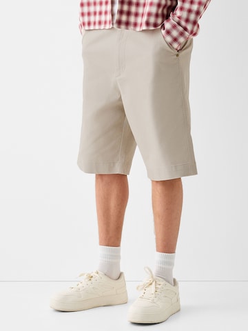 Bershka Loose fit Chino trousers in Beige: front