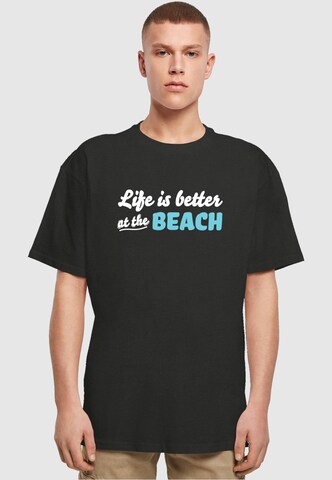 Merchcode T-Shirt 'Summer - Life Is Better At The Beach' in Schwarz: Vorderseite