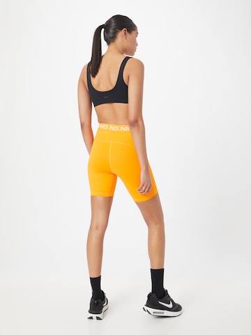 NIKE Skinny Spodnie sportowe 'Pro 365' w kolorze pomarańczowy
