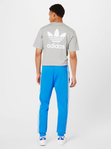 ADIDAS ORIGINALS Zwężany krój Spodnie 'Adicolor Classics Sst' w kolorze niebieski