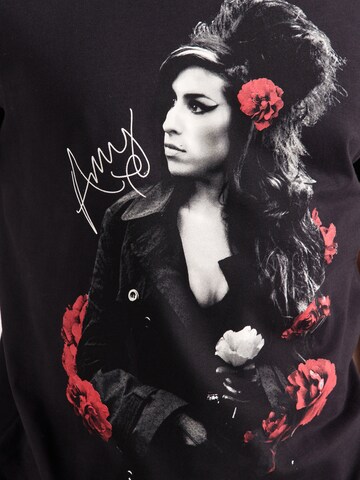 AMPLIFIED Paita 'AMY WINHOUSE-POSES WITH ROSES' värissä musta