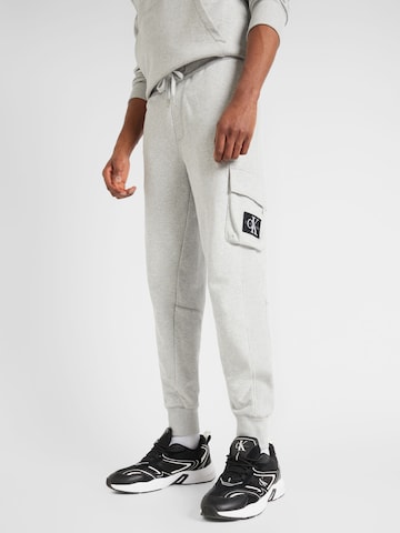 Calvin Klein Jeans - Tapered Calças em cinzento: frente