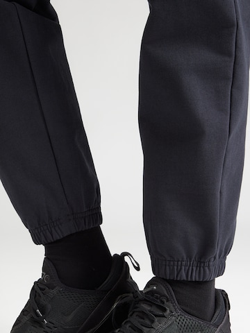 UNDER ARMOUR Tapered Sports trousers in Black
