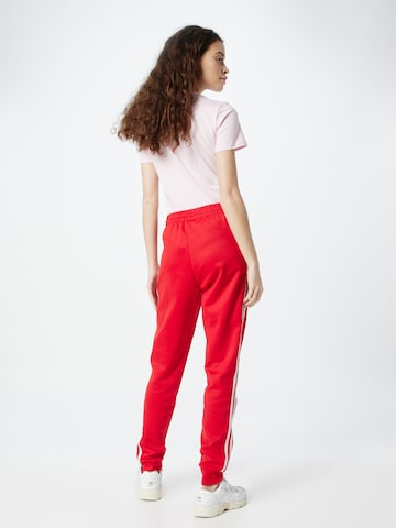 ADIDAS ORIGINALS - Tapered Pantalón 'Adicolor Classics Cuffed' en rojo