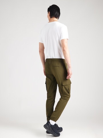 Effilé Pantalon de sport 'Vibe' UNDER ARMOUR en vert