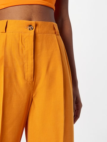 NÜMPH - Perna larga Calças com vincos 'MERCEDES' em laranja