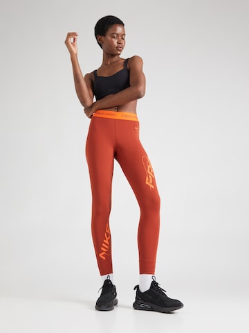 NIKE Skinny Sportbroek in Oranje