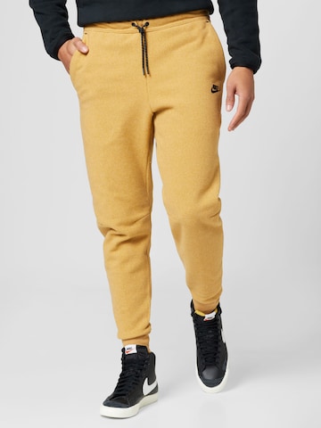 Nike Sportswear Tapered Trousers in Yellow: front