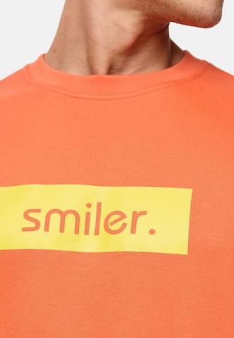 Sweat-shirt smiler. en orange
