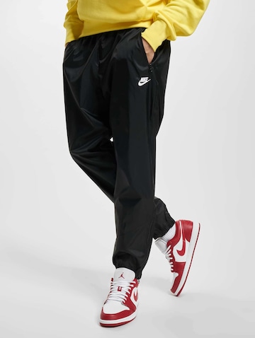 NIKE Tapered Sports trousers in Black: front