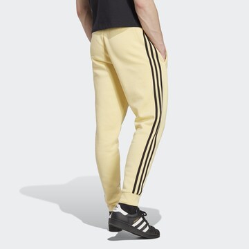 ADIDAS ORIGINALS Slimfit Housut 'Adicolor Classics' värissä keltainen