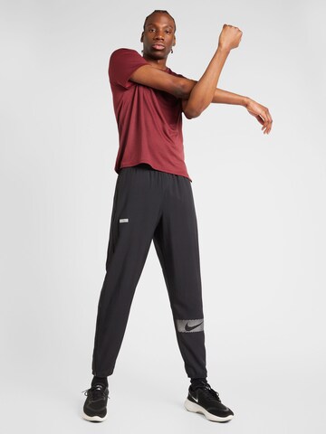 NIKE Zwężany krój Spodnie sportowe 'FLSH CHALLENGER' w kolorze czarny