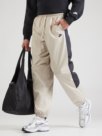 bēšs Nike Sportswear Pakapēniski sašaurināts piegriezums Bikses: no priekšpuses