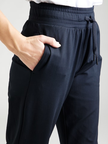 UNDER ARMOURLoosefit Sportske hlače 'Motion' - crna boja