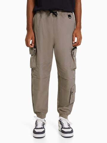 Bershka Tapered Cargo trousers in Grey: front