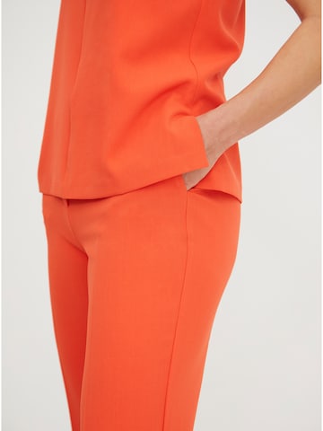 ABOUT YOU x Iconic by Tatiana Kucharova Flared Pants 'Jillian' in Orange