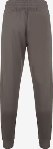 Effilé Pantalon de sport UNDER ARMOUR en marron