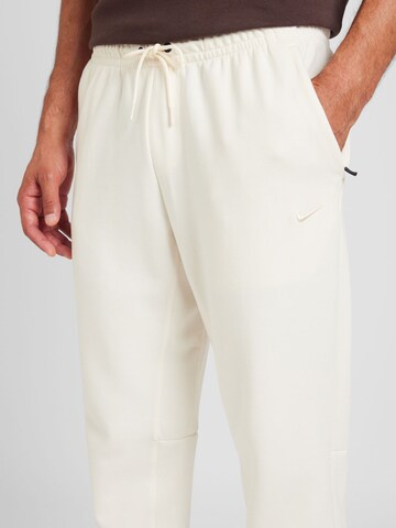 NIKETapered Sportske hlače 'PRIMARY' - bež boja