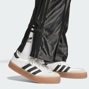 ADIDAS ORIGINALS Lużny krój Spodnie 'Firebird' w kolorze czarny
