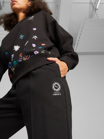 PUMA Zwężany krój Spodnie 'PUMA X LIBERTY' w kolorze czarny