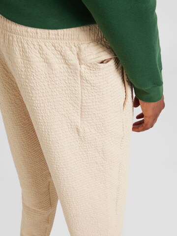 Tapered Pantaloni sportivi di NIKE in beige