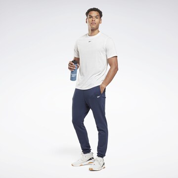 Reebok - Tapered Pantalón deportivo en azul