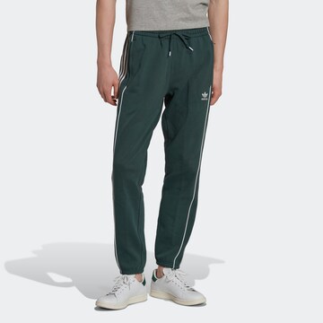 Tapered Pantaloni 'Rekive' de la ADIDAS ORIGINALS pe verde: față