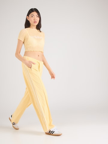 ADIDAS ORIGINALSLoosefit Hlače 'Firebird' - žuta boja