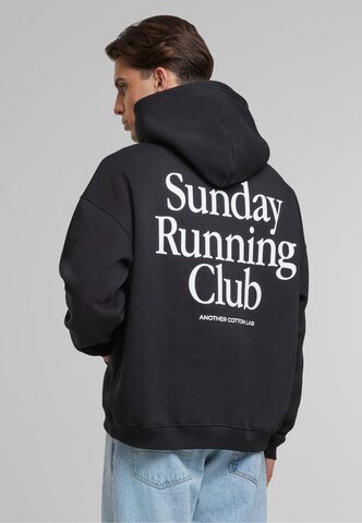 Bluză de molton 'Sunday Running Club' de la Another Cotton Lab pe negru: față