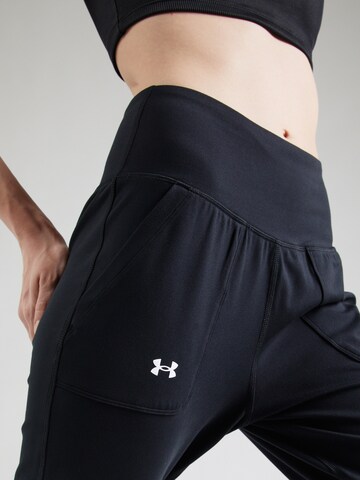 UNDER ARMOUR Tapered Urheiluhousut 'Motion' värissä musta