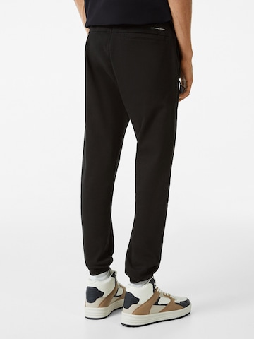 Bershka Дънки Tapered Leg Панталон в черно