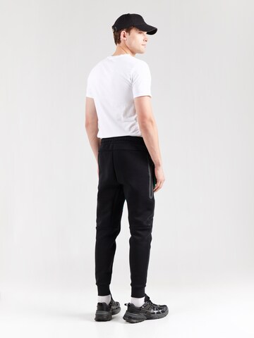 Tapered Pantaloni 'TCH FLC' de la Nike Sportswear pe negru