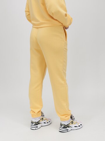Effilé Pantalon 'VIBE' UNFOLLOWED x ABOUT YOU en jaune : derrière