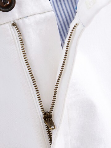 Next Slimfit Chinohousut värissä valkoinen