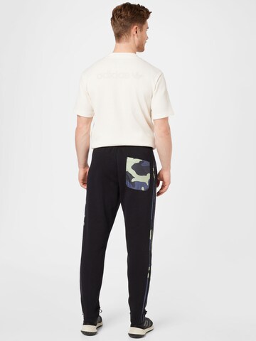 Tapered Pantaloni 'Graphics Camo Sweat' di ADIDAS ORIGINALS in nero