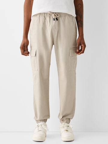 Bershka Tapered Gargohousut värissä beige: edessä