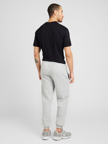 Tapered Pantaloni 'ESSENTLS' di NEW ERA in grigio