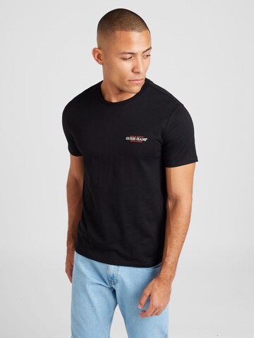 T-Shirt 'American Tradition' GUESS JEANS en noir : devant