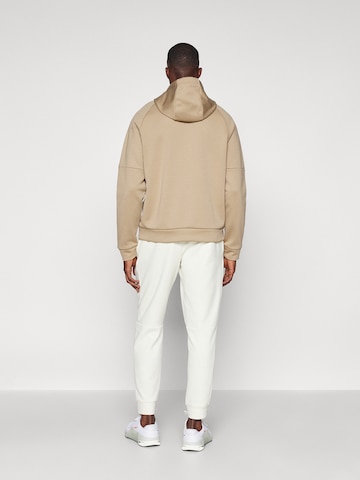 NIKE Tapered Sports trousers 'PRIMARY' in Beige