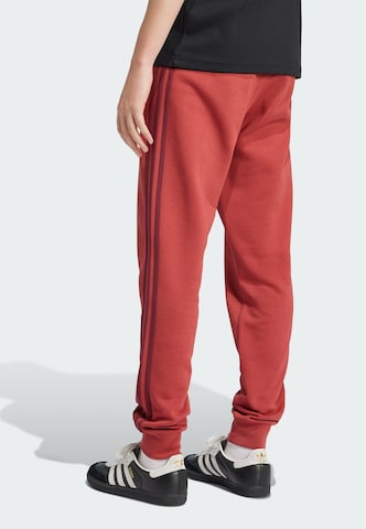 ADIDAS ORIGINALS - Tapered Pantalón 'Adicolor' en rojo